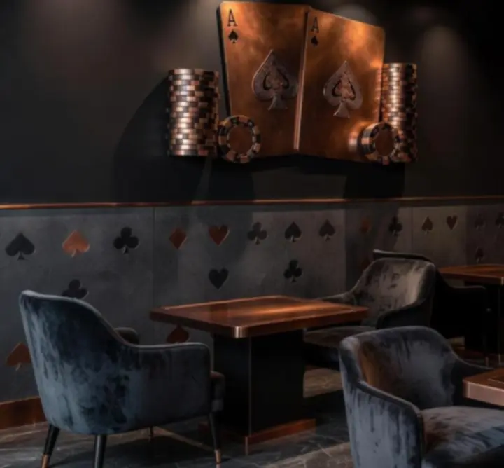 Wnętrze restauracji w czerni i miedzi, przygotowane na wieczór pokerowy